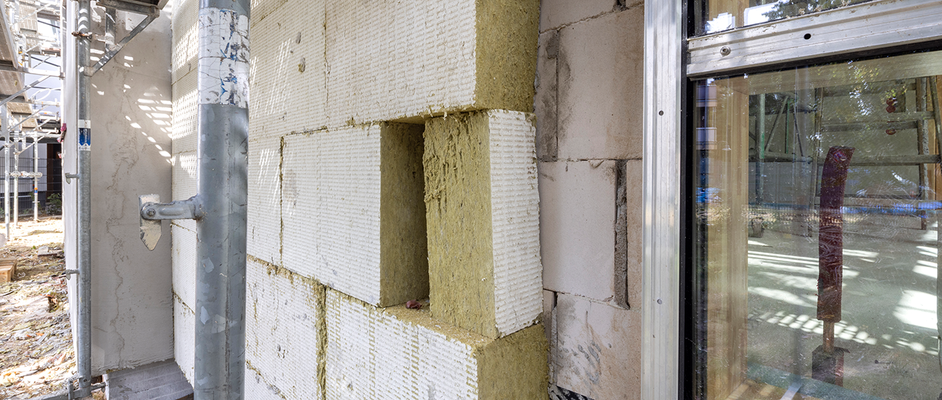 Wärmedämmung Hespenheide 1 Fassadendämmung mit Dämmplatten an Gebäudeaußenwand während Sanierungsarbeiten.